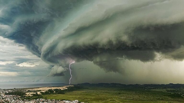 Nuvens densas de tempestade com raio sobre área urbana em imagem de fenômeno meteorológico e alerta de temporal