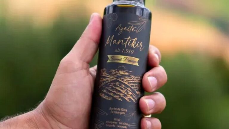 Pessoa segura garrafa de azeite Mantikir em ambiente externo destacando produto premium de oliva extra virgem