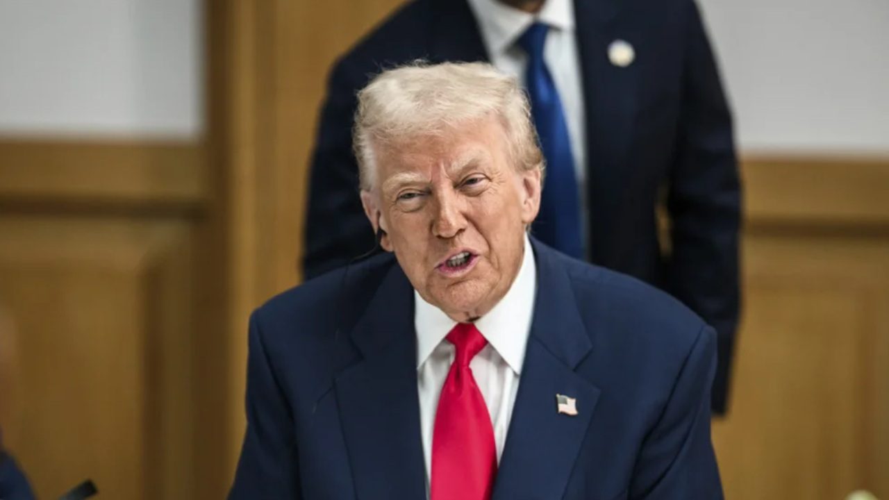 Imagem de Donald Trump com um terno escuro, uma camisa branca e gravata vermelha